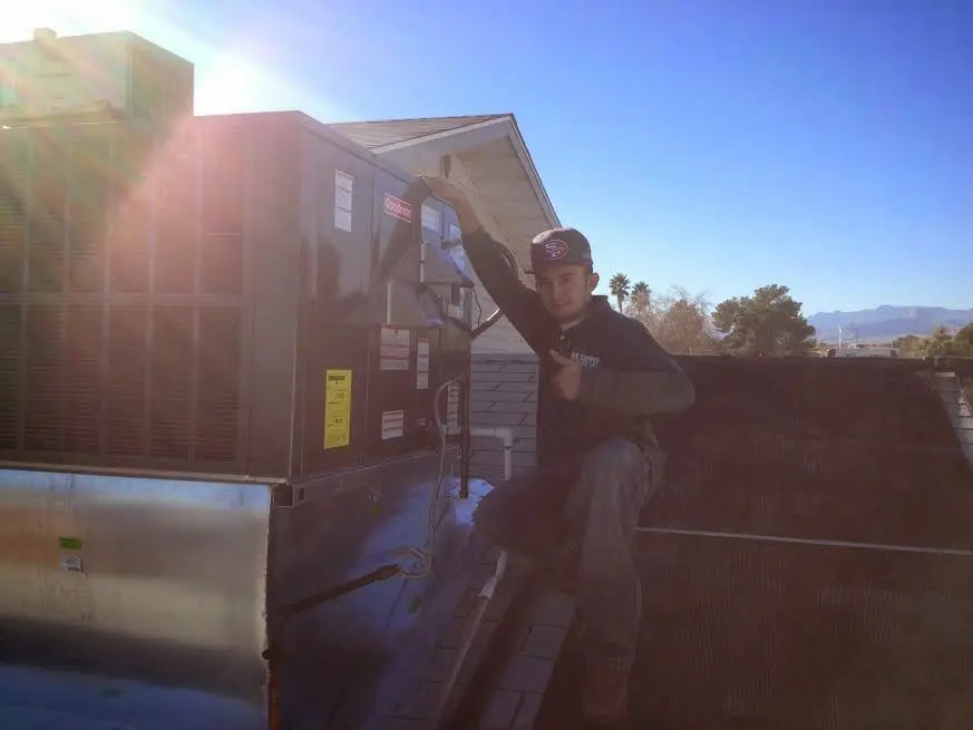 HVAC technician performing HVAC Inspection on a rooftop unit in Monticello